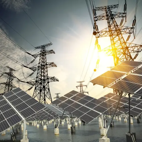 Photovoltaik-Panelpark mit Hochspannungsmasten im Hintergrund